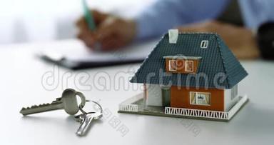 <strong>房产中介</strong>办公室桌上的房屋比例模型和钥匙
